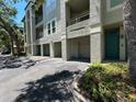 Low angle exterior shot of condo featuring garage, balcony and teal front door at 622 Seascape Way, Tampa, FL 33602