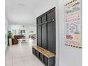 The entryway features a bench with storage and view to the spacious living room and dining room at 6384 Ten Acre Ct, Zephyrhills, FL 33541