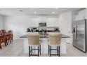 Modern kitchen featuring granite countertops, stainless steel appliances, and white cabinets at 6384 Ten Acre Ct, Zephyrhills, FL 33541