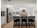 Bright kitchen with white cabinets, granite countertops, and stainless steel appliances, island with seating at 656 40Th Ne Ave, St Petersburg, FL 33703