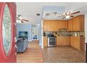 Bright, open-concept layout showcasing a well-equipped kitchen with wooden cabinets, tile flooring, and stainless steel appliances at 6982 78Th N Ave, Pinellas Park, FL 33781