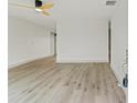 Bright living room featuring contemporary wood-look flooring, neutral walls and modern ceiling fan at 7400 Belvedere Ter, New Port Richey, FL 34655