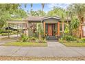Inviting home exterior showcasing a well-manicured lawn, carport, and charming front porch, enhancing curb appeal at 916 E Broad St, Tampa, FL 33604