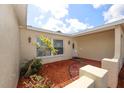Welcoming front entrance with covered porch, attractive landscaping, and brick paved walkway at 9816 Crofton Ln, Port Richey, FL 34668