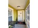 Covered front porch featuring a welcome mat, a table and a white front door at 10411 Summerview Cir, Riverview, FL 33578