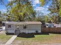 Cozy single-story home with a covered porch, gray siding, and a walkway leading to the entrance at 10501 Bay Hills Cir, Thonotosassa, FL 33592