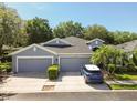 Inviting single-story home with a three-car garage, a well-manicured yard and mature landscaping at 10716 Ashford Oaks Dr, Tampa, FL 33625