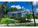 Charming exterior of a gray home featuring manicured landscaping and a well-maintained lawn at 10716 Ashford Oaks Dr, Tampa, FL 33625