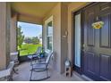 Cozy front porch with seating area and welcoming decor with view of lush green lawn at 11924 Brighton Knoll Loop, Riverview, FL 33579