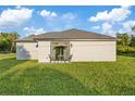 Exterior of the property with a grassy backyard, patio and outdoor furniture at 12106 Clarendon Ave, Port Charlotte, FL 33981
