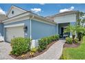 Charming home exterior featuring a lush landscaped pathway leading to a cozy porch with seating at 12817 Cobalt Ter, Bradenton, FL 34211