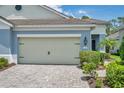 Charming home with a two-car garage, lush landscaping, and a paved driveway leading up to the entrance at 12817 Cobalt Ter, Bradenton, FL 34211