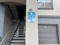 Building signage shows unit numbers above gray private garages, stairs, and walkways at 13243 Sanctuary Cove Dr # 204, Temple Terrace, FL 33637