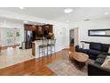Open-concept living room showcasing wood floors, a dark sofa, and a kitchen with granite countertops at 173 21St Se Ter, Largo, FL 33771