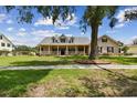 Inviting single-Gathering home with a spacious front yard, covered porch, and mature shade trees at 2202 Colewood Ln, Dover, FL 33527