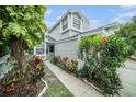 A well-maintained townhome with lush landscaping leading to the front entrance at 2456 Alhambra St, Clearwater, FL 33761