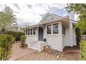 Quaint exterior showcasing a covered porch with striped awnings and manicured bushes at 246 18Th Ne Ave, St Petersburg, FL 33704