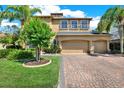 Stunning two-story house with a three-car garage, a paver driveway, and lush landscaping at 2614 Brookforest Dr, Wesley Chapel, FL 33544