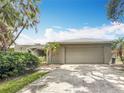 Home with a 2-car garage, featuring a neutral exterior and a manicured lawn at 2742 Sea Pines E Cir, Clearwater, FL 33761