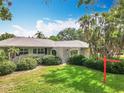 Well-maintained home with lush landscaping, featuring a stucco exterior and a manicured lawn at 2742 Sea Pines E Cir, Clearwater, FL 33761