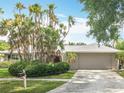 Well-maintained home with lush landscaping, featuring a neutral exterior and a manicured lawn at 2742 Sea Pines E Cir, Clearwater, FL 33761