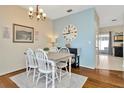 Comfortable dining room with wood floors, modern chandelier, and decorative wall art at 30140 Barnaby Ln, Wesley Chapel, FL 33543