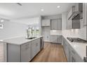 Bright, open kitchen featuring gray cabinets, stainless steel appliances, and a spacious island at 35609 Stableton Lane, Zephyrhills, FL 33541