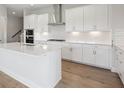 Modern kitchen featuring white cabinets, stainless steel appliances, subway tile backsplash, and center island at 35617 Stableton Lane, Zephyrhills, FL 33541