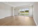 Bright living room with hardwood floors and large glass sliding doors with lake views at 35617 Stableton Lane, Zephyrhills, FL 33541