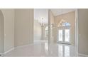 Bright foyer featuring tile flooring, soaring ceilings, arched windows, and elegant chandeliers at 3610 Woodbridge Ave, North Port, FL 34287