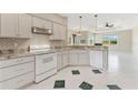 Well-equipped kitchen with granite countertops, white cabinets, and tile flooring at 3610 Woodbridge Ave, North Port, FL 34287