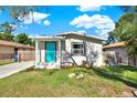 Charming home featuring a bright teal front door and a well-maintained lawn at 3708 N 56Th St, Tampa, FL 33619