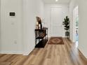 Entryway featuring wood floors, a rug, decorative console table, and neutral colored walls at 3952 Almond Brook Blvd, Land O Lakes, FL 34638