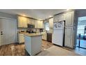 Bright kitchen with an island, farmhouse sink, stainless appliances, and ample cabinet space at 39772 Meadowood Loop, Zephyrhills, FL 33542