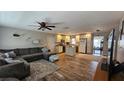 Open-concept living room and kitchen with modern finishes and wood-look floors at 39772 Meadowood Loop, Zephyrhills, FL 33542