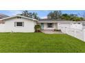 Inviting single-story home showcasing a lush lawn and a bright blue door at 4709 W Fair Oaks Ave, Tampa, FL 33611