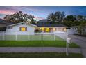 Quaint single-story home showcasing a lush lawn, a picket fence, and a convenient mailbox at 4709 W Fair Oaks Ave, Tampa, FL 33611