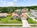 An aerial view of a single-Gathering home with solar panels in a neighborhood with mature landscaping at 5405 El Cerro Dr, New Port Richey, FL 34655