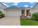 Inviting single-Gathering home with a two-car garage, complemented by manicured landscaping and a colorful front door at 5492 Summer Sunset Dr, Apollo Beach, FL 33572