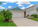 Attractive one-story house with a two-car garage, complemented by mature palm trees and landscaped front yard at 5492 Summer Sunset Dr, Apollo Beach, FL 33572