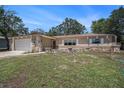 Charming single-story home featuring stone accents, a two-car garage, and a well-maintained lawn at 6241 Ansley St, Spring Hill, FL 34606