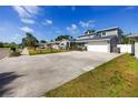 Expansive driveway leading to a well-maintained two-story home with manicured lawn and landscaping at 6536 115Th Ln, Seminole, FL 33772