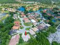 Stunning aerial view of a waterfront community featuring lush landscaping and serene lake views, perfect for tranquil living at 6933 Cozumel Ct, Land O Lakes, FL 34637