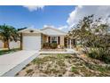 Inviting one-story home with a clean driveway, front yard garden, and stone detailing on the facade at 699 Merlins Ct, Tarpon Springs, FL 34689
