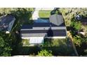 Aerial view of a home featuring solar panels on roof, patio, and fenced backyard at 7014 Doreen St, Tampa, FL 33617