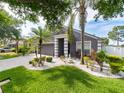 Landscaped front yard with palm trees and a charming home with a two-car garage at 8508 Canterbury Lake Blvd, Tampa, FL 33619