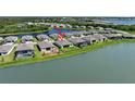 Gorgeous aerial view of the home with a lake view and featuring a screened in patio at 8589 Saint Kitts Cir, Englewood, FL 34224