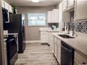 Modern kitchen with white cabinets, stainless steel appliances, and stylish backsplash at 10233 N Valle Dr, Tampa, FL 33612
