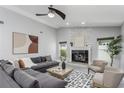 Bright living room featuring a stone fireplace, modern furniture, and ample natural light at 1028 Wyndham Way, Safety Harbor, FL 34695