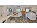 Open-concept living room with wood-look floors, lots of natural light, and ceiling fan at 1129 Emerald Hill Way, Valrico, FL 33594